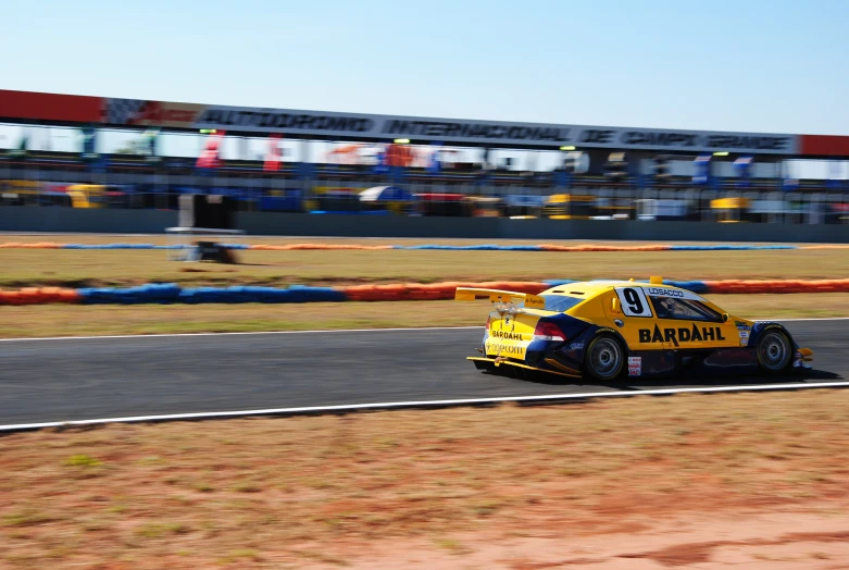 a race car drives through a race track with spectators watching