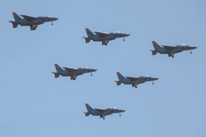 four planes flying in formation under a blue sky