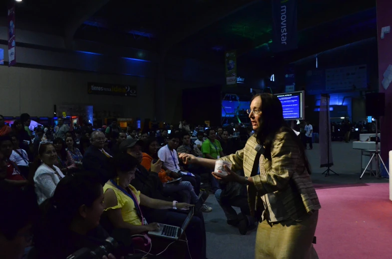 an adult in a large crowd is shown at a presentation