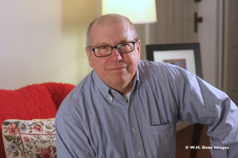 a man sitting on a couch looking at the camera