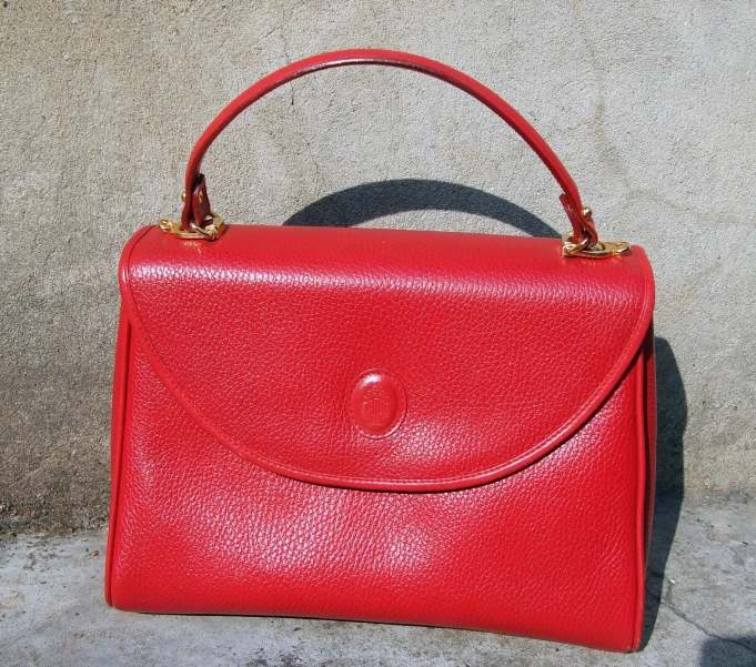 a red purse sitting on the side of a building