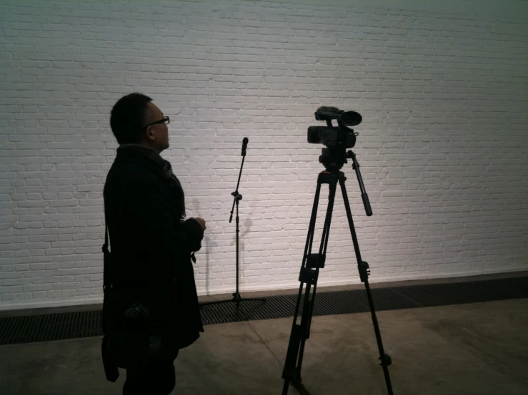 a camera sitting on top of a tripod in front of a brick wall