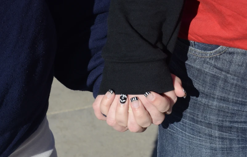 two people with manies holding hands while one has nails with small designs on them