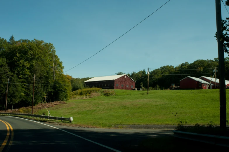 a big grass covered field that has a few houses in it