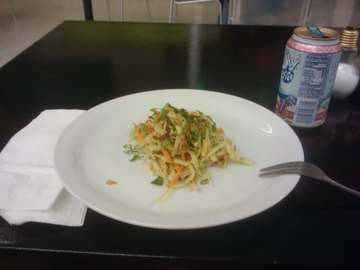 pasta is on the white plate next to a can