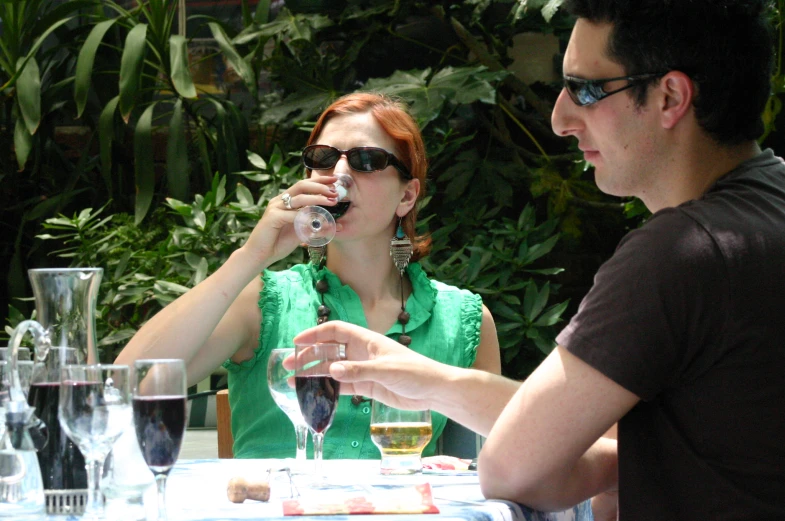 man and woman drinking red wine together on outdoor patio