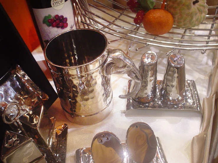 three pairs of silver shoes sitting in front of an empty wine bottle