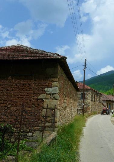 a rural road next to some old stone buildings