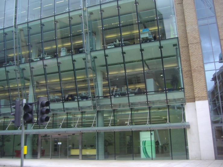 a modern glass building with some traffic lights