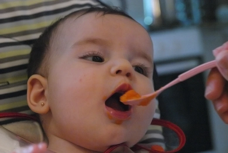 a baby eating soing out of a spoon