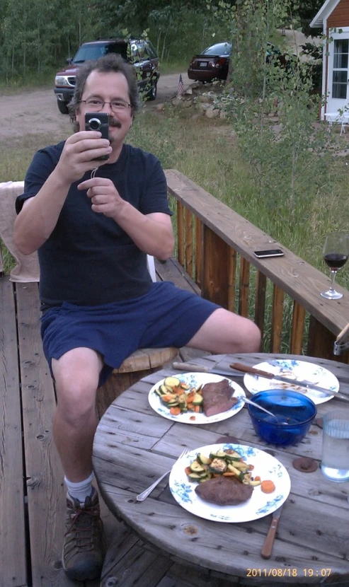 a man taking a selfie while sitting at a table