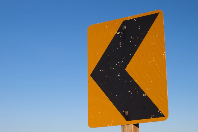 an orange sign with black arrow pointing downward