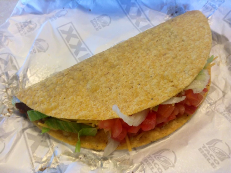 a taco on top of paper wrapped in plastic wrapper