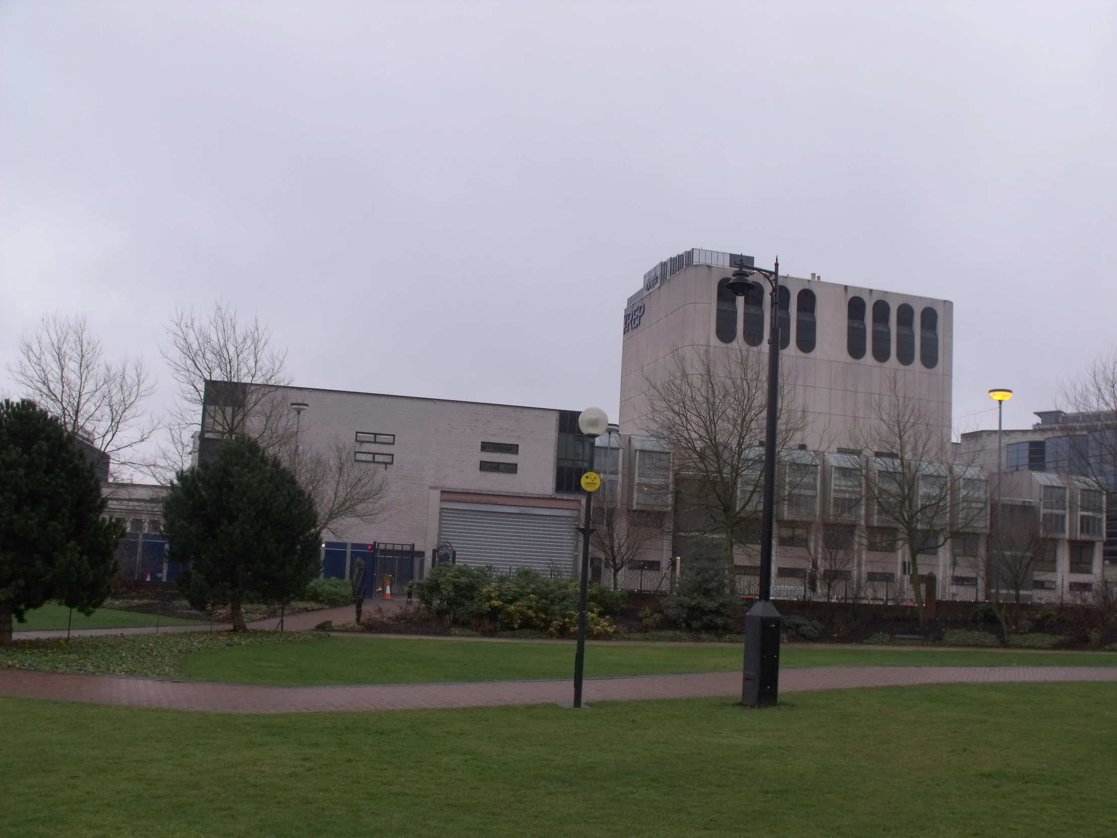 some buildings on a cloudy day with green grass