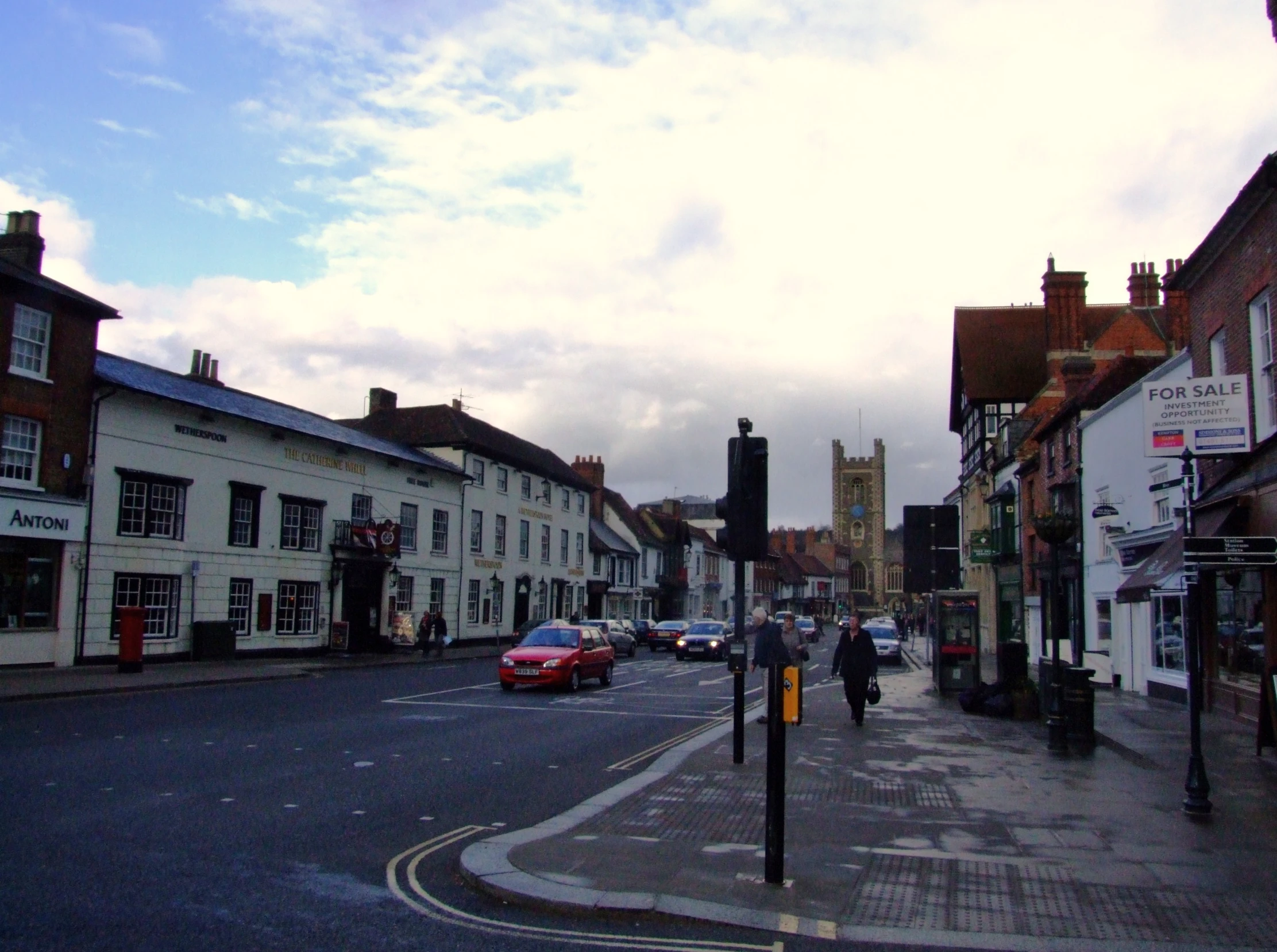 two buildings are seen on the corner of a busy street