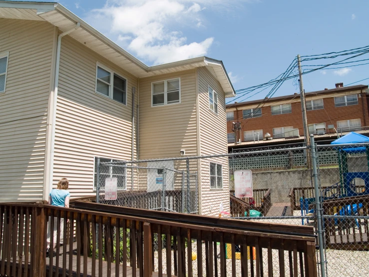 two white houses in the middle of a fenced backyard