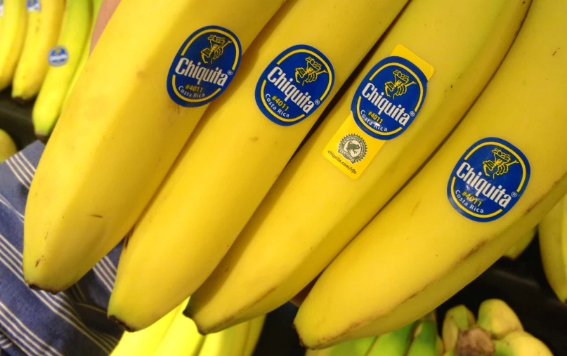 many bunches of bananas with stickers on them