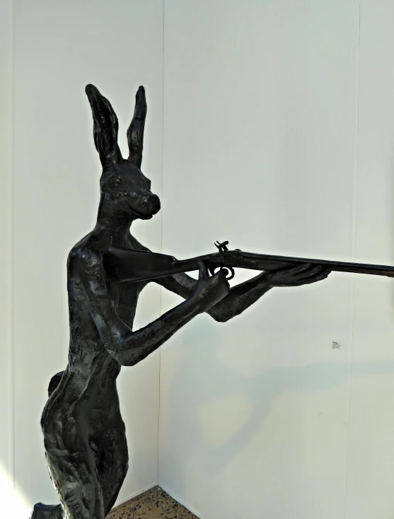 a sculpture of a man that is holding a rifle