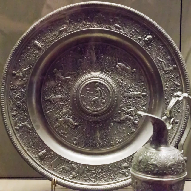 a very unique metal plate with a pitcher in the middle