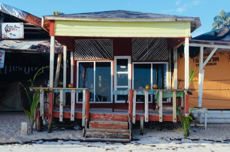 this small beach cottage has orange shutters and a roof