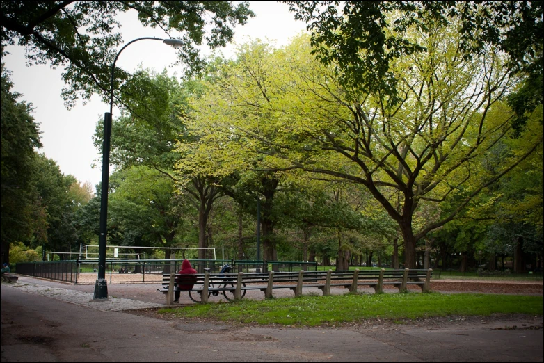 a person riding a bike past a park bench