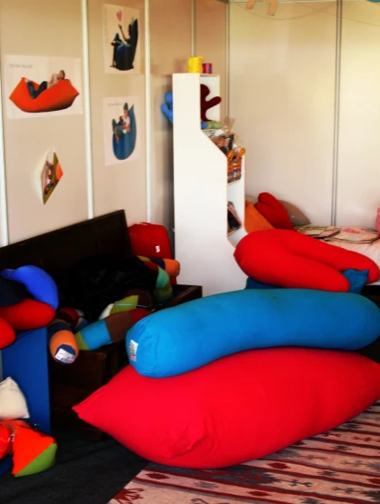 this room has many colored pillows on the floor