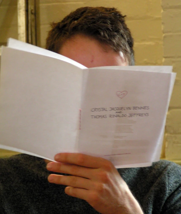 a man in glasses reading from an open book