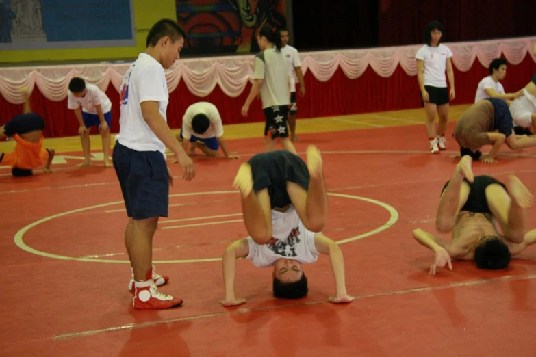 a group of men standing on their stomachs in a gym