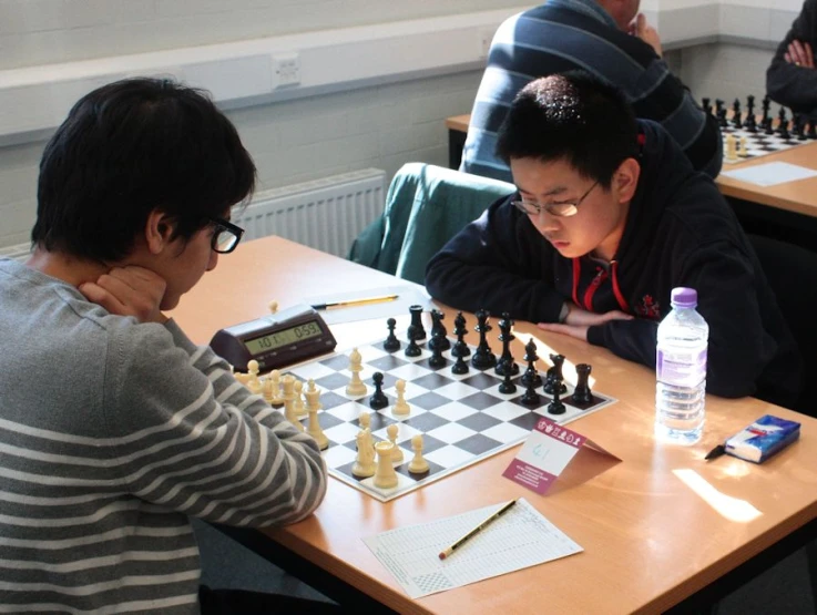 two people playing a game of chess on the table