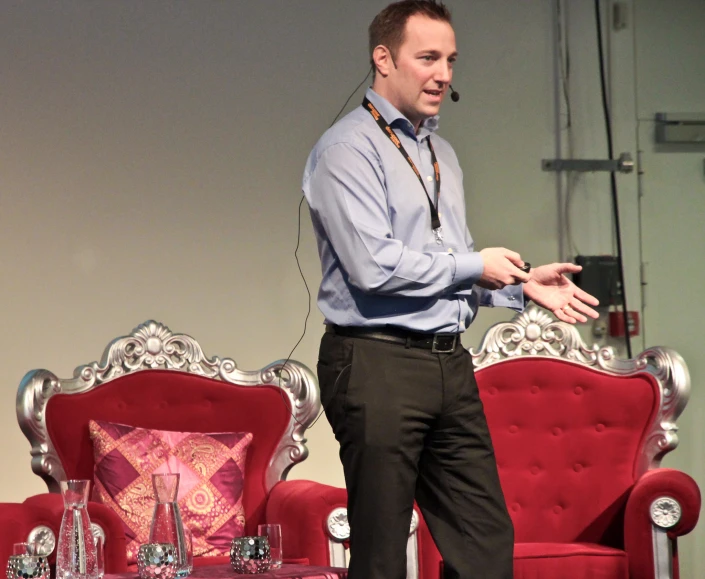 a man is standing in front of a red sofa