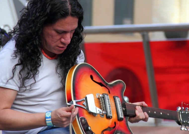 woman in white shirt playing an electric guitar at a festival