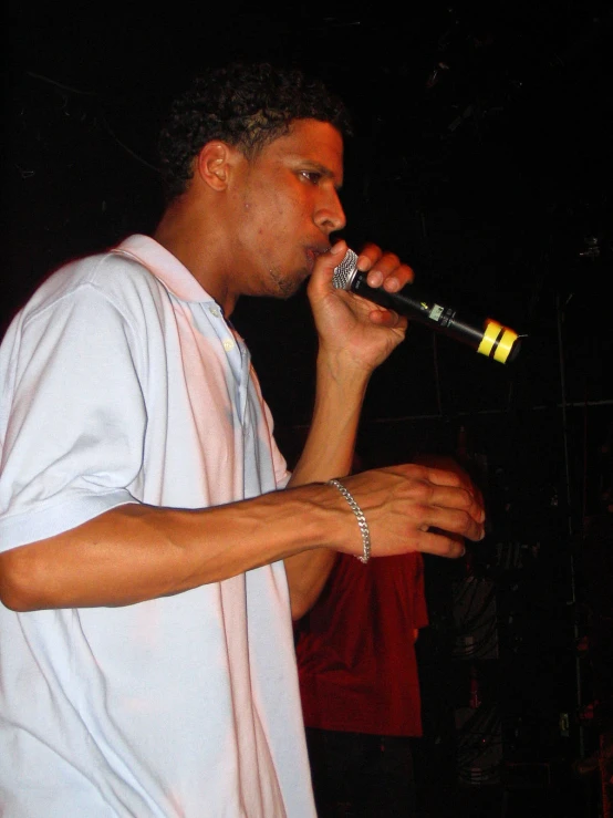 a male singer in a white shirt singing into his microphone