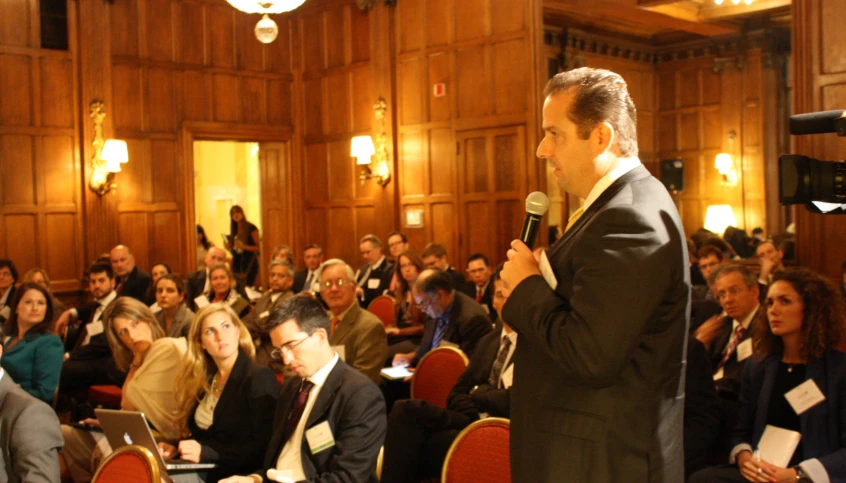 a man in suit and tie speaking to a crowd