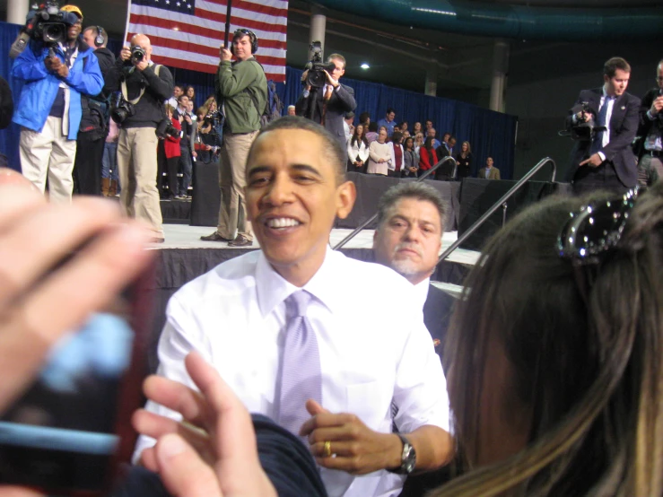 a crowd takes pictures of obama during the event