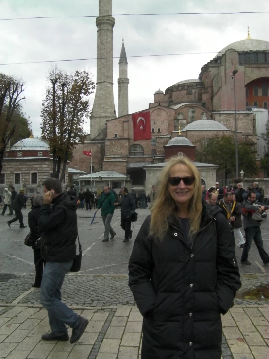 a woman standing next to a crowd on a street