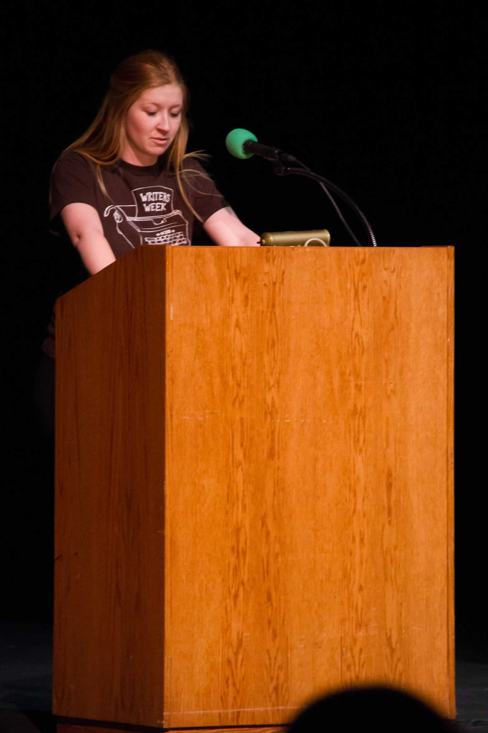 a woman is speaking from a podium with a microphone