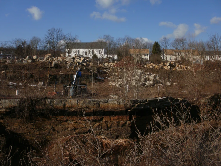 an abandoned bridge surrounded by barren terrain, houses and trees