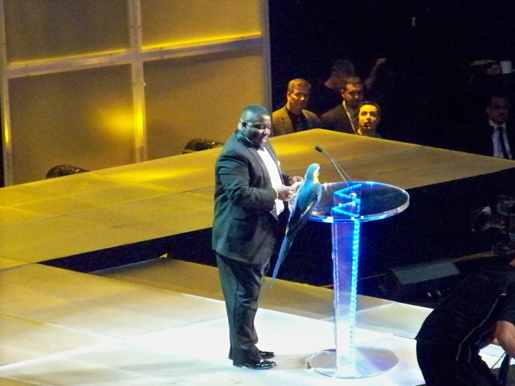 a man stands in front of a podium holding a microphone