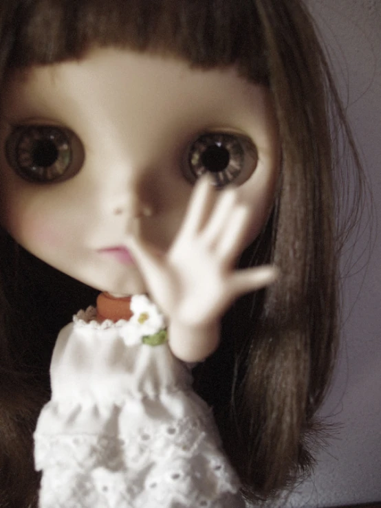 an image of a doll posing with her hand on the face