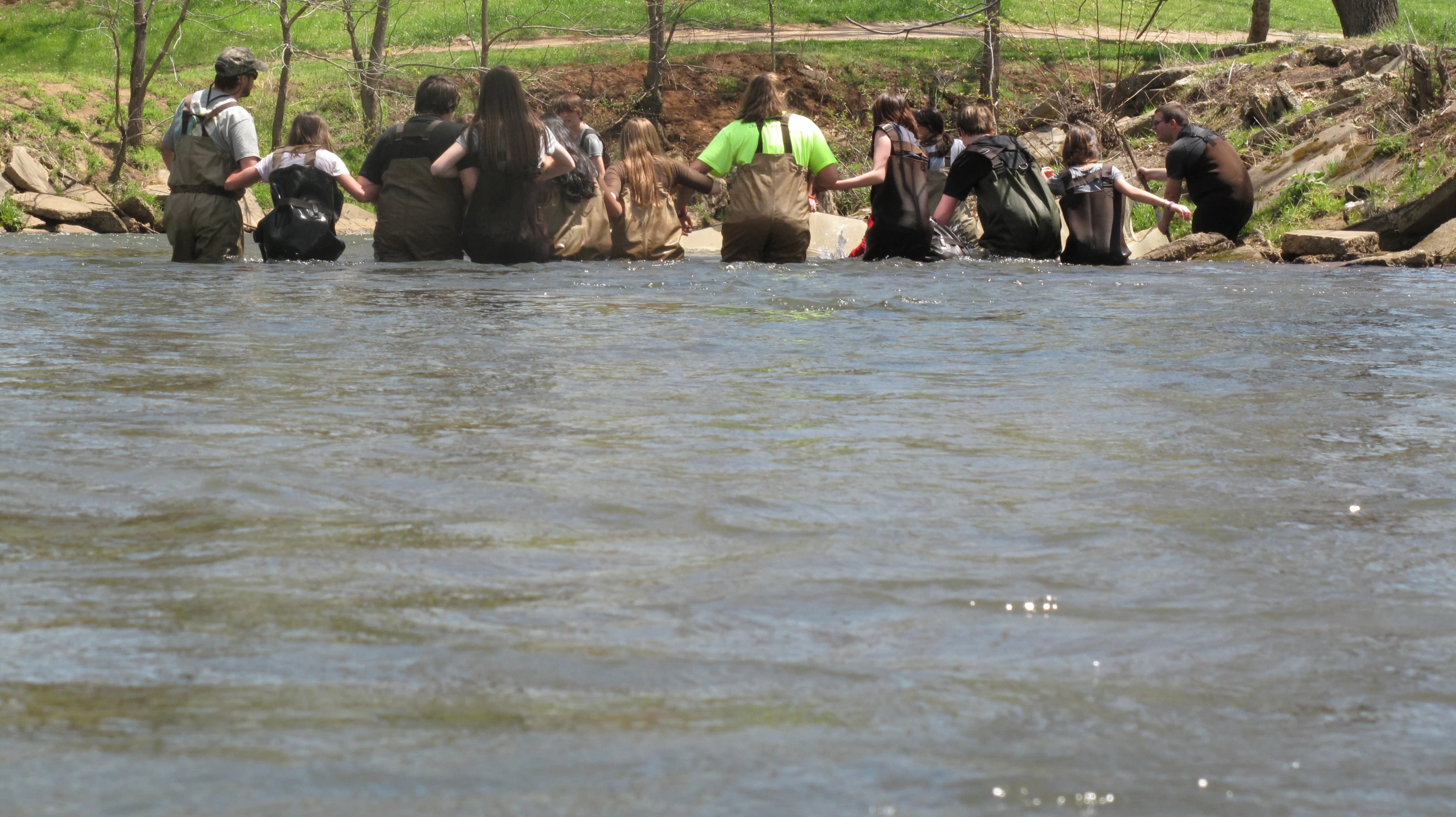 people near a body of water at the edge of a trail