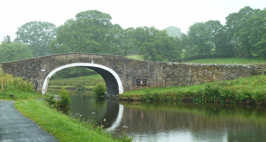 a bridge with water running under it that has a stone path next to it