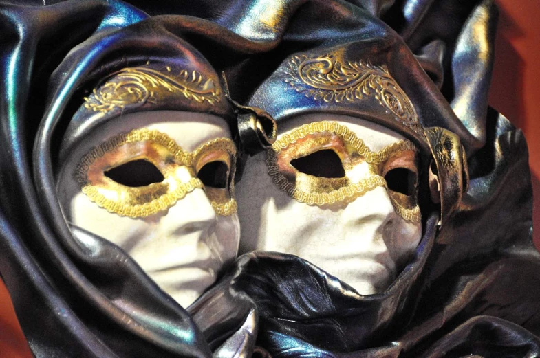 two white maskes wrapped in a black piece of cloth