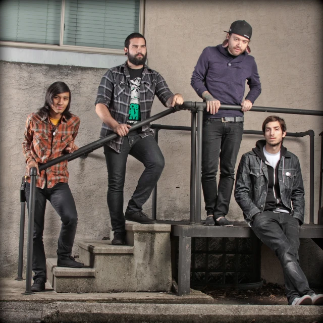 four people standing on steps next to each other