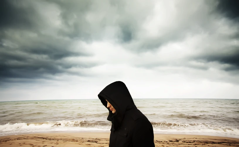 a person on a beach with dark clouds