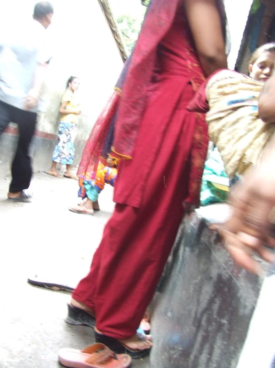 a person with a large red cape on walking around a group of people