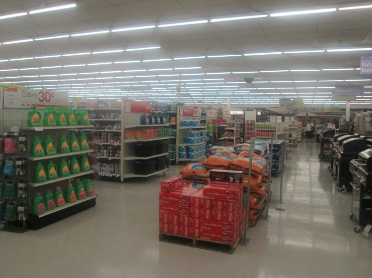 the shop aisle is crowded with goods being displayed