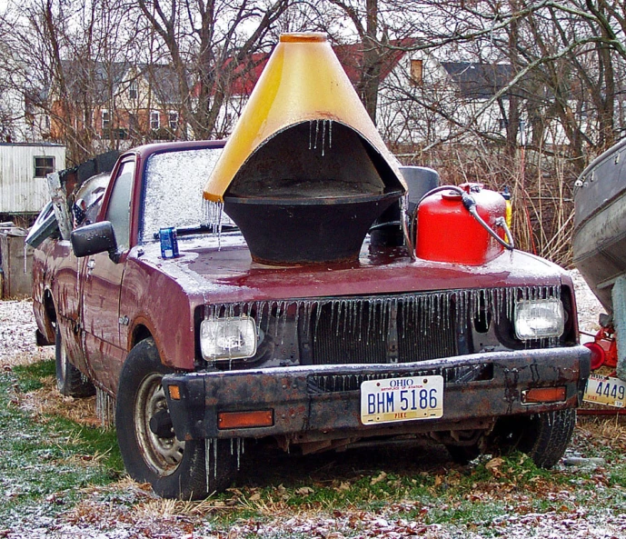 an old truck with its hood up parked outside