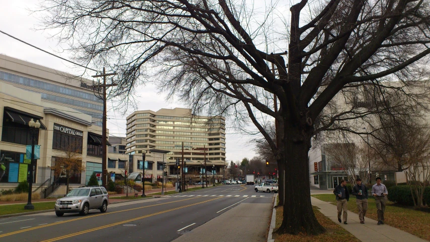 some people walk down a street near buildings