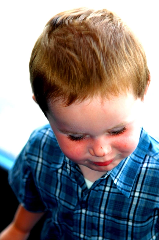 a toddler with red eyes looking down at soing