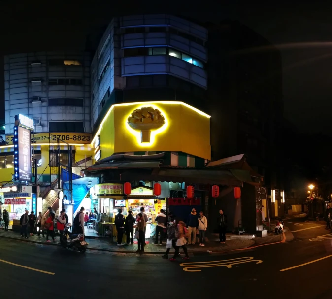 people are outside at night time walking along the street